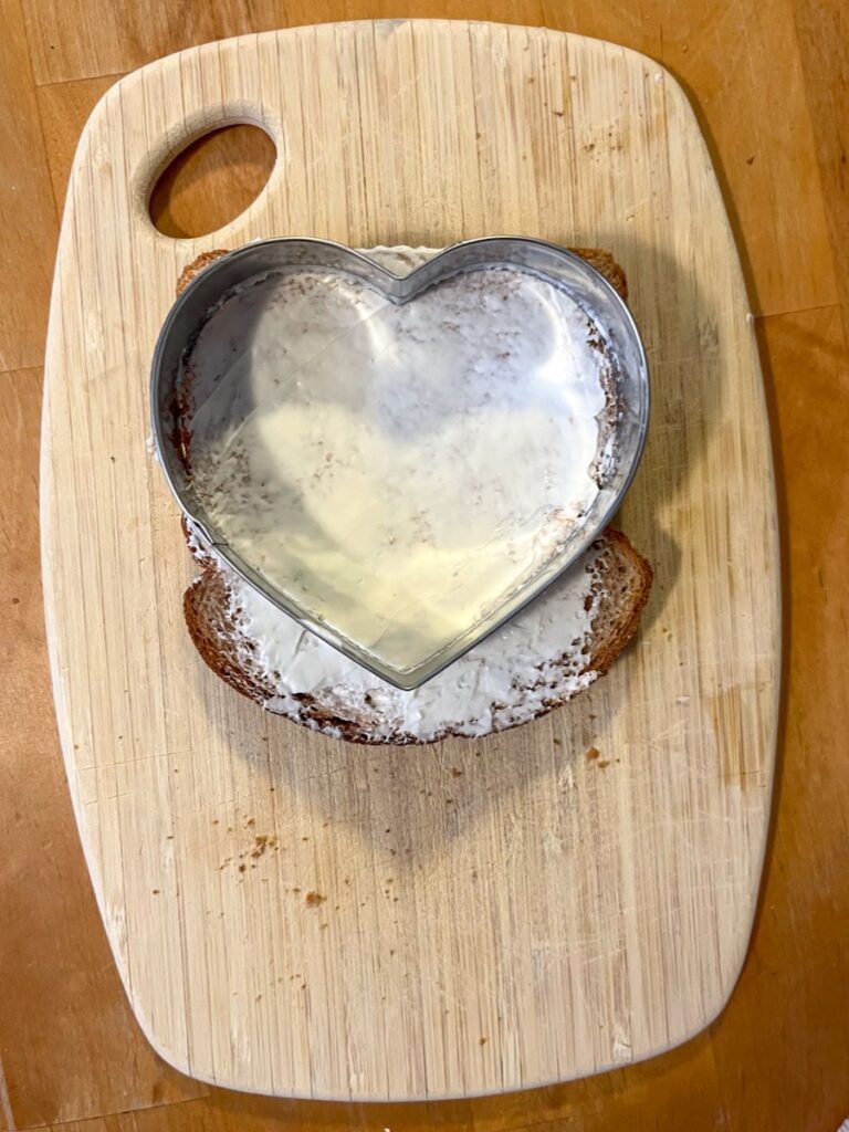 piece of bread with cream cheese and cookie cutter on top