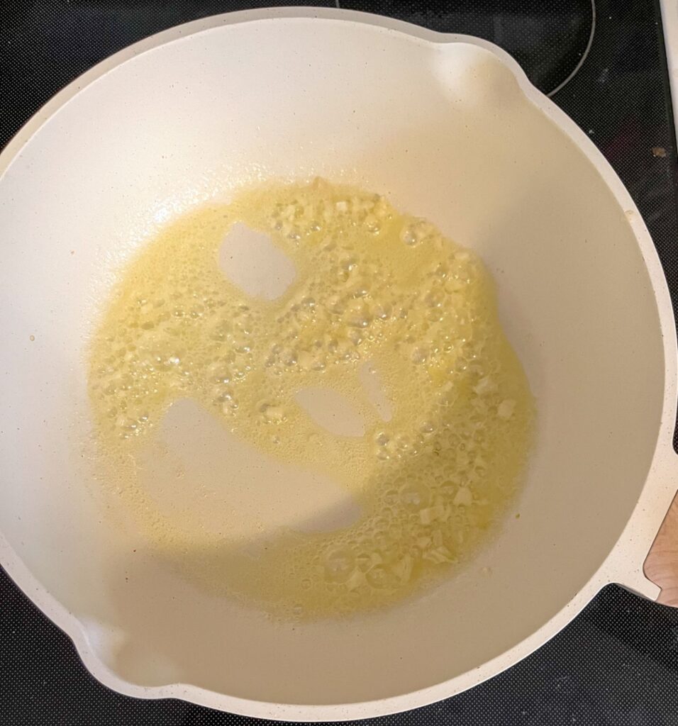 butter and garlic being sauteed in a saucepan