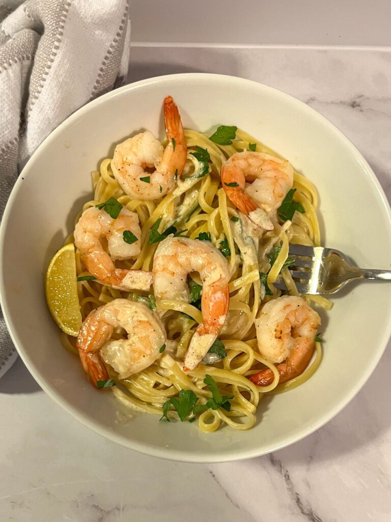 Creamy lemon shrimp pasta in a bowl topped with shrimp and parsley