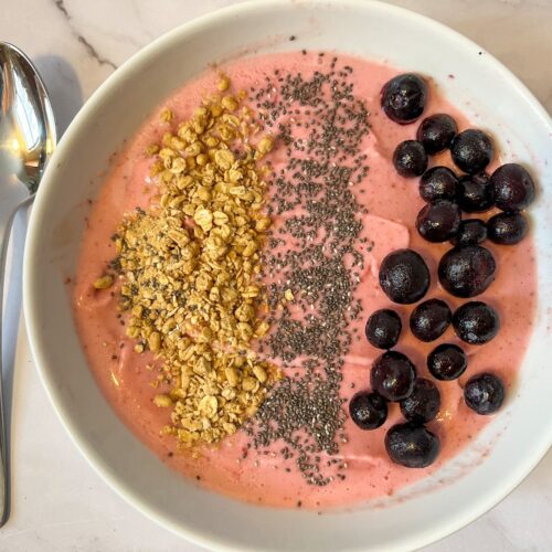 strawberry smoothie bowl with a spoon served next to it