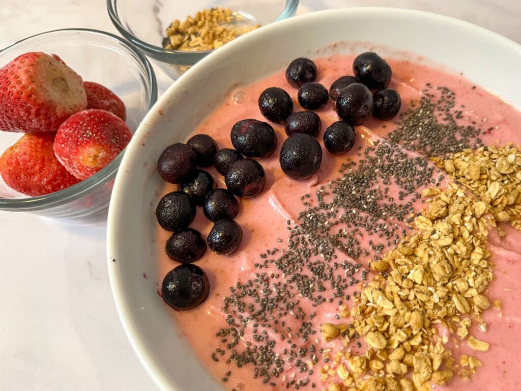 strawberry smoothie bowl with blueberries, chia seeds, and granola served in a bowl