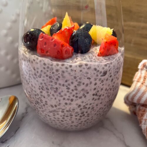 Berry chia seed pudding served in a glass with chopped berries on top