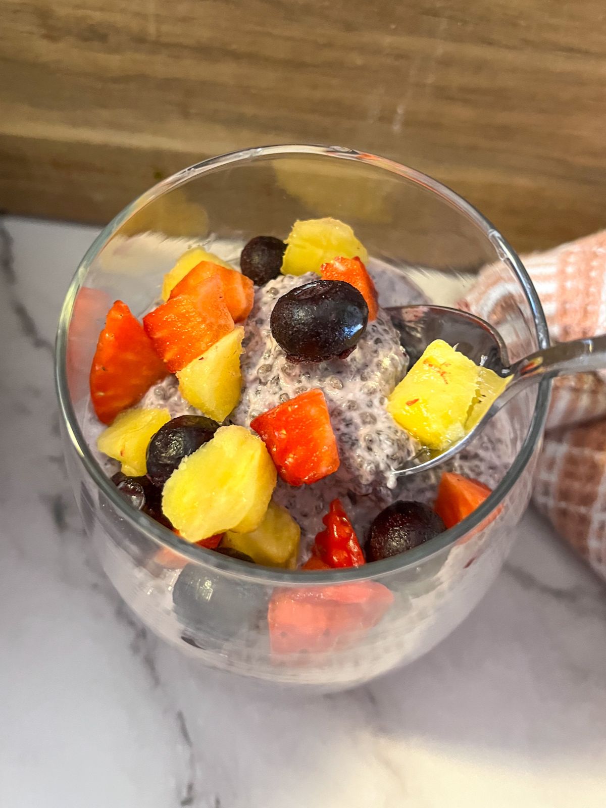 berry chia seed yogurt being scooped out of a cup