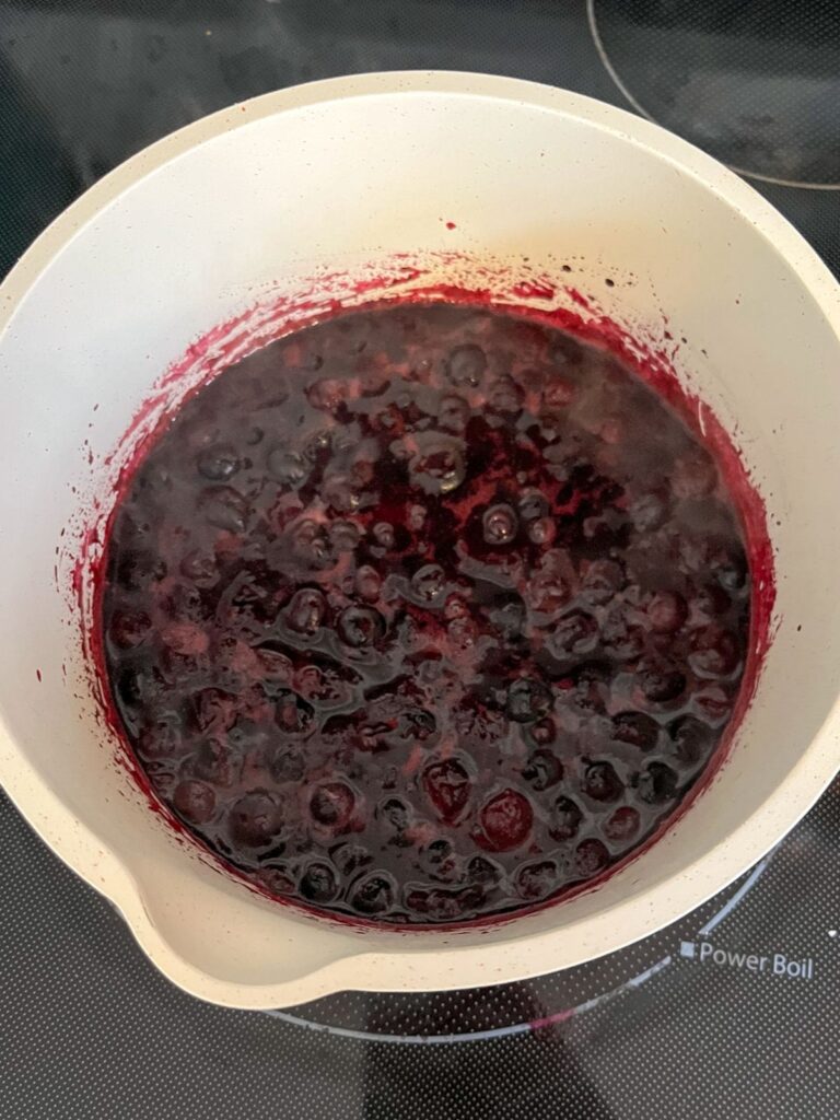 Blueberries syrup simmering in a saucepan