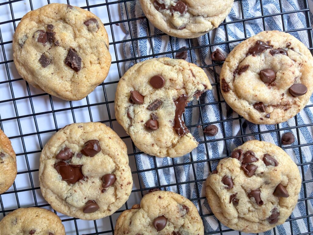 eggless chocolate chip cookies on a cooling rack with a bite taken out