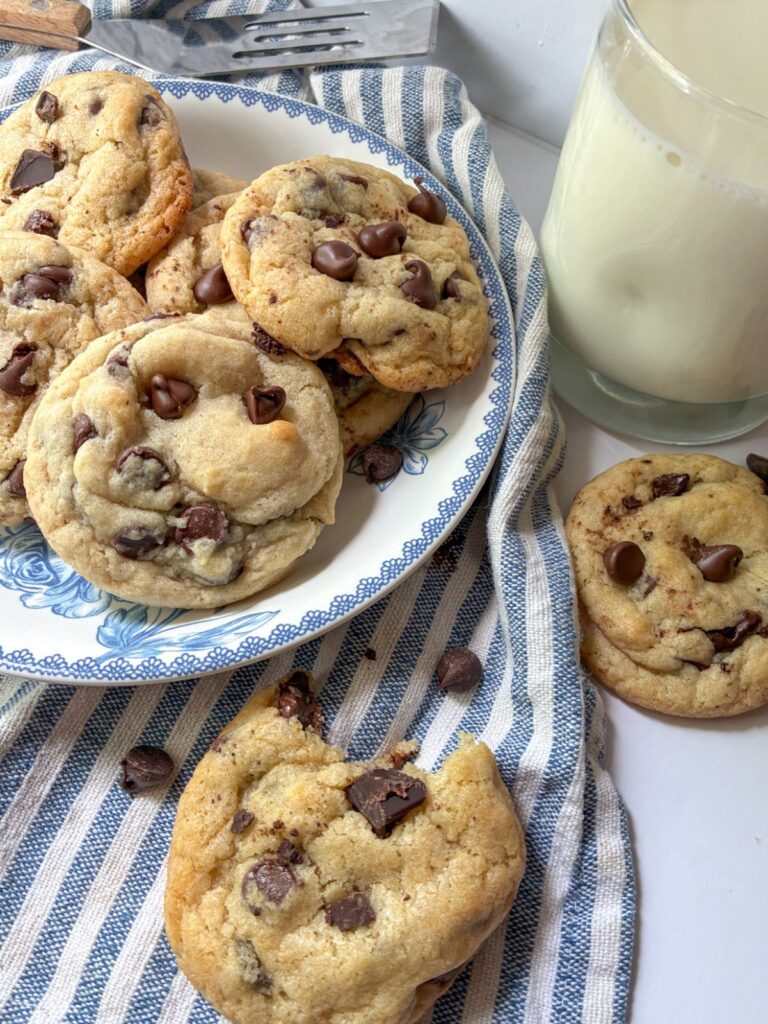 Eggless chocolate chip cookies on a plate and with a glass of milk