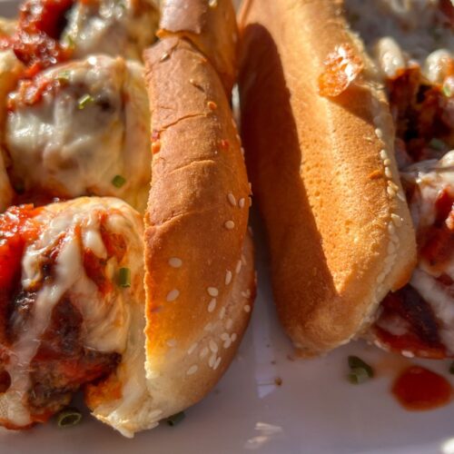 Two eggless meatball subs on a plate