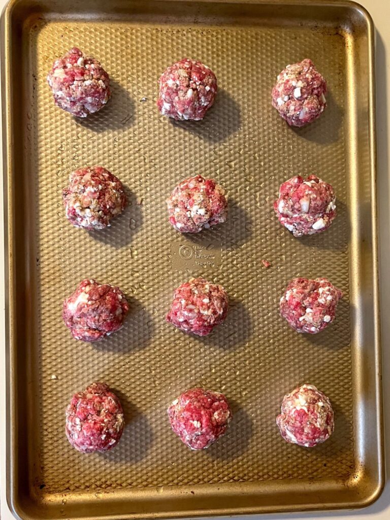 12 eggless Meatballs formed and placed on a baking sheet