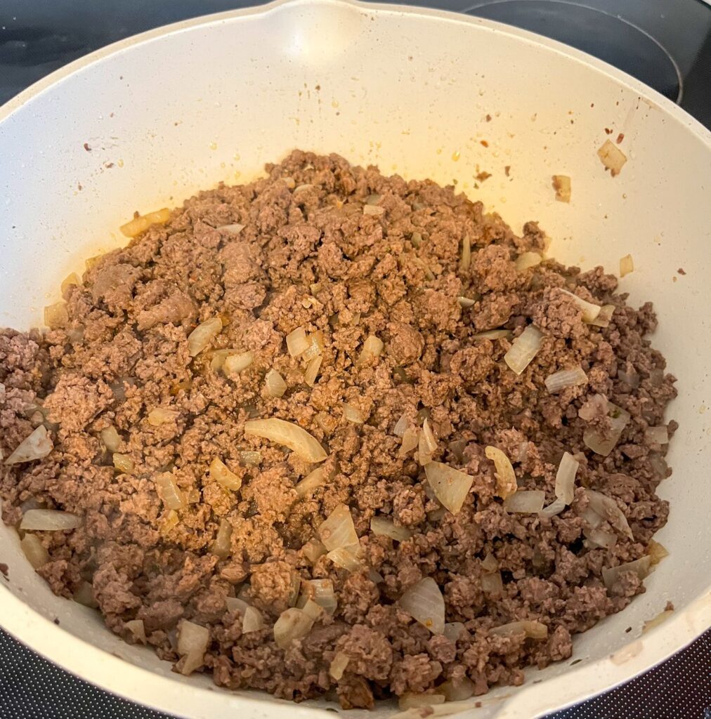 cooked ground beef in skillet with onion