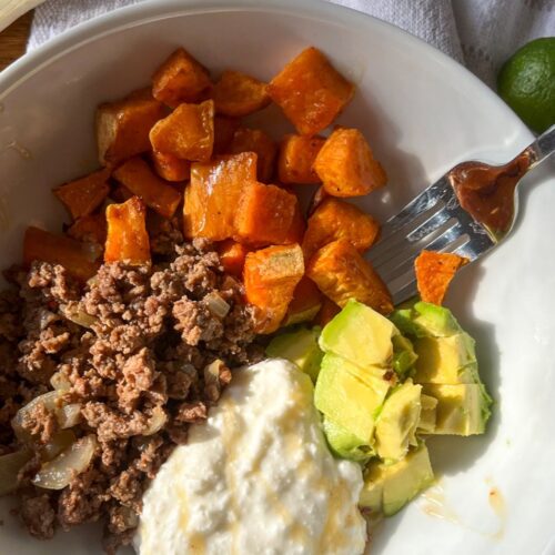 Ground beef hot honey bowl with a wooden spoon next to it