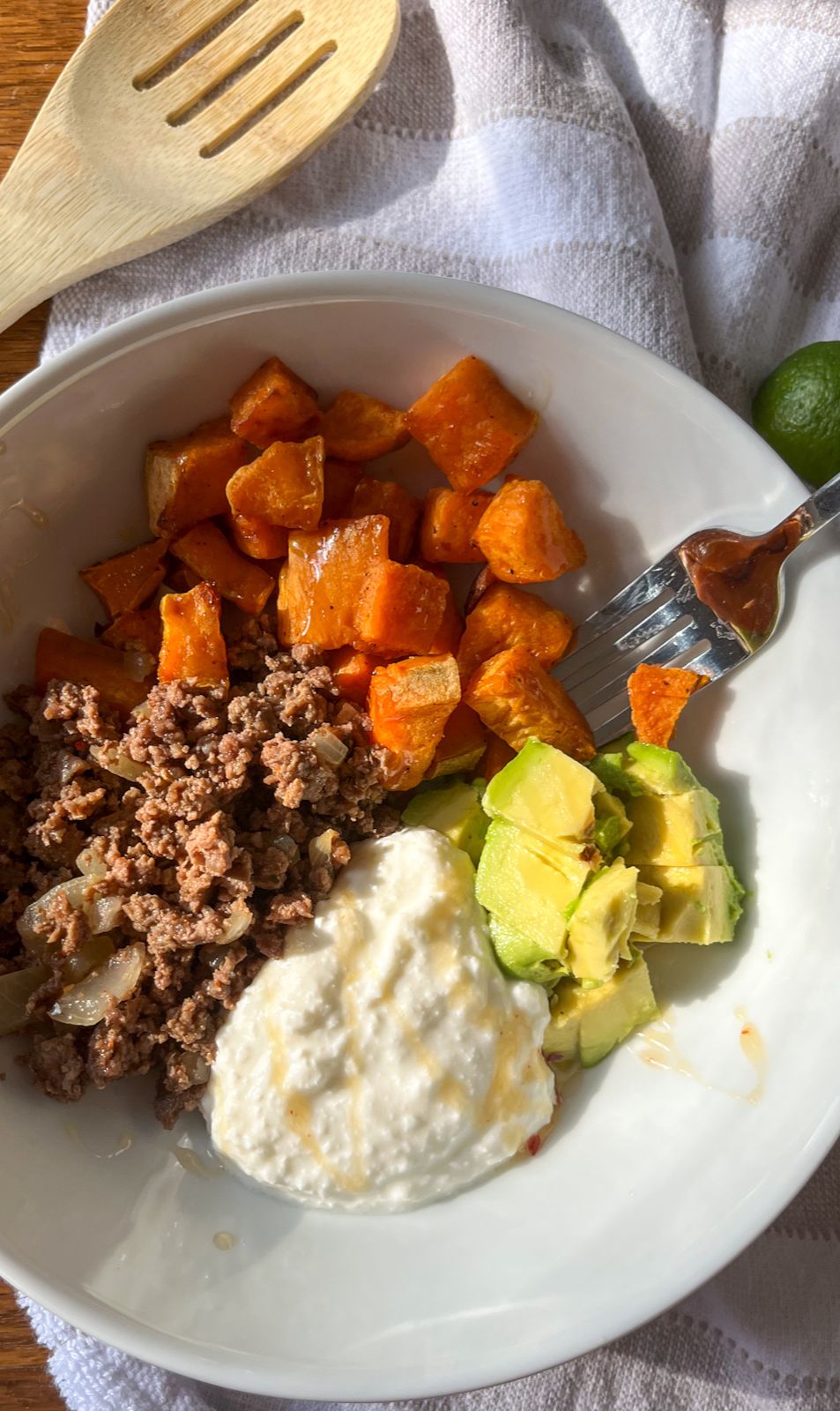 Ground beef hot honey bowl with a wooden spoon next to it