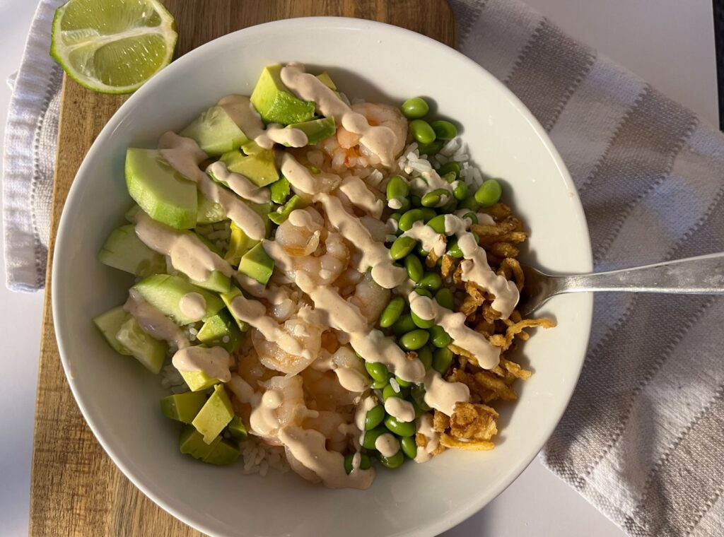 shrimp and rice bowl served in a bowl with a fork
