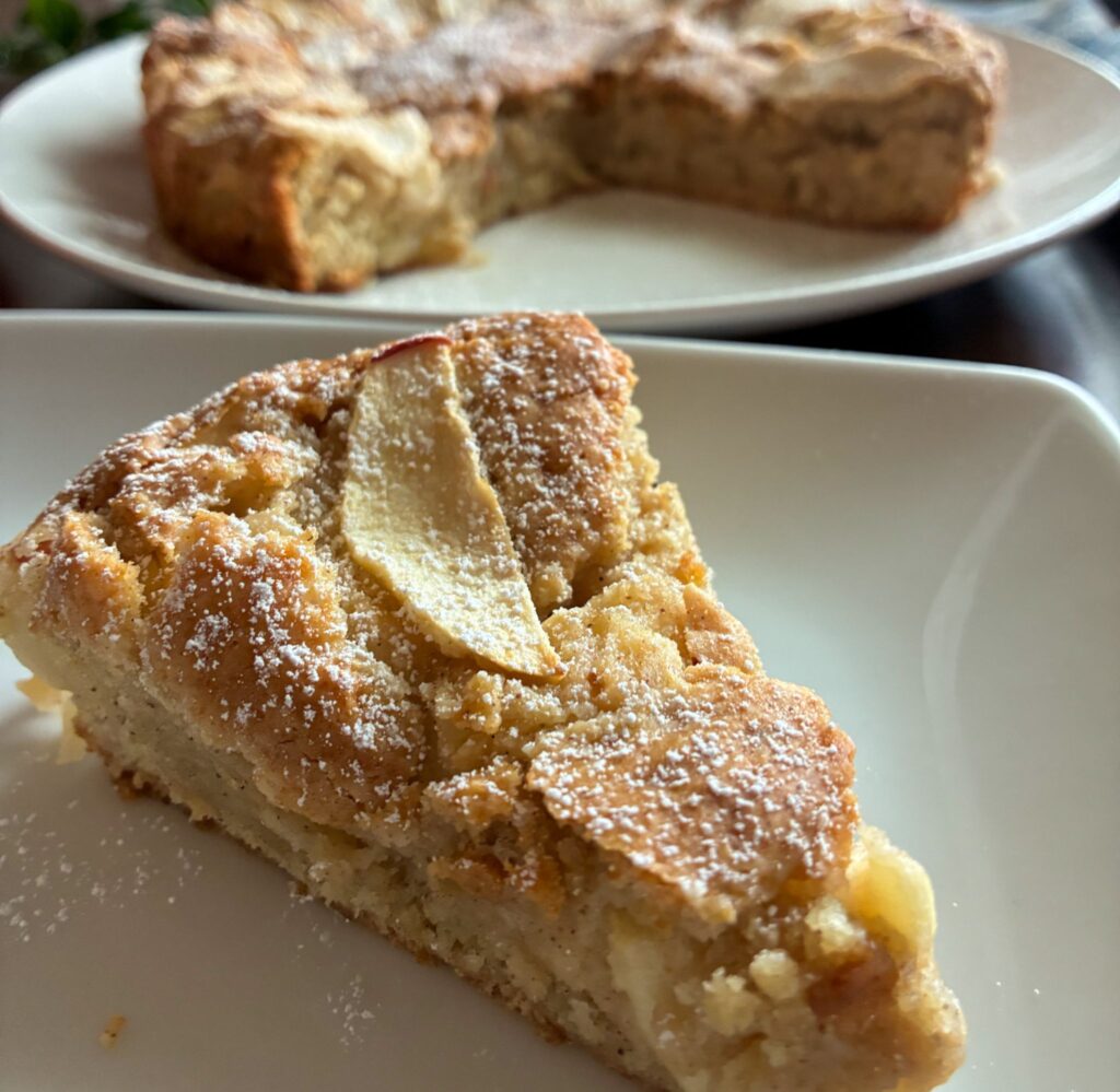 Slice of eggless apple cake served on plate