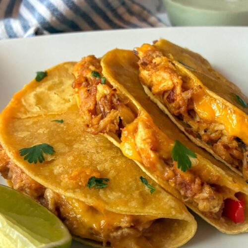 Three baked chicken tacos laying out on a plate