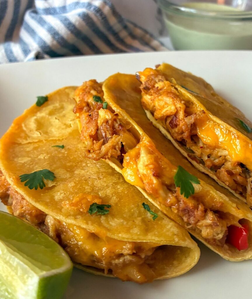 Three baked chicken tacos laying out on a plate