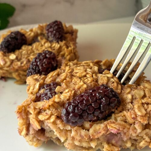 blackberry oatmeal bake slices on a plate with a fork in it