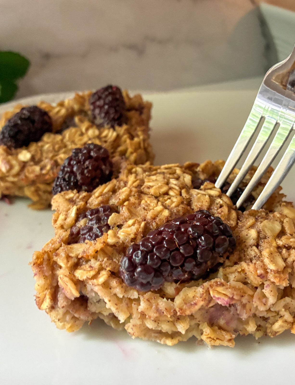 blackberry oatmeal bake slices on a plate with a fork in it
