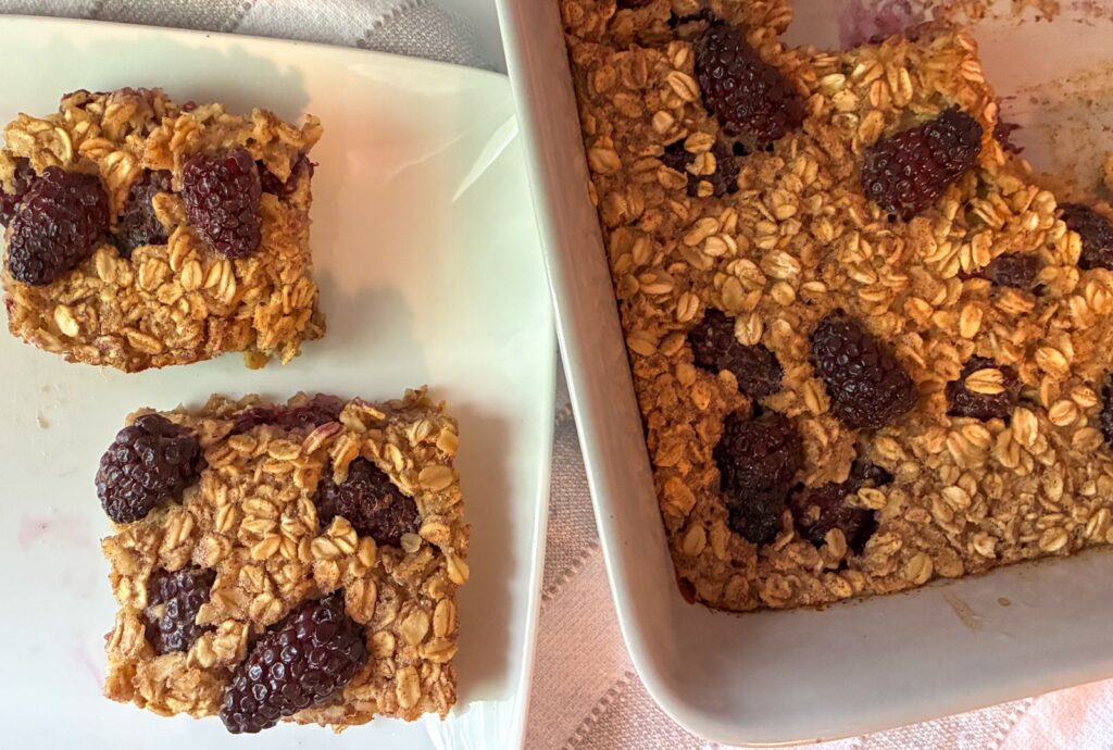 Blackberry oatmeal bake served in a cooking dish and two slices on a plate