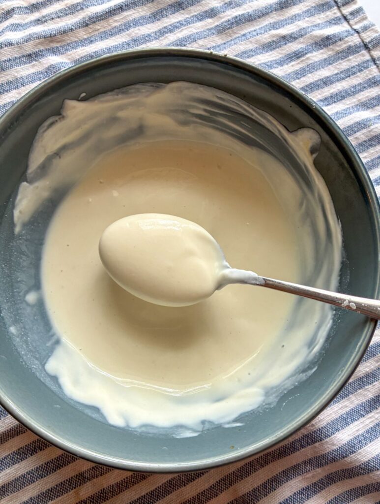 honey mustard sauce in a bowl with a spoon scooping it out