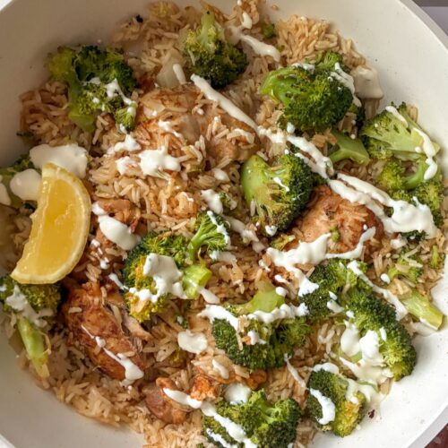 chicken and rice skillet still in the skillet with cream sauce drizzled on top.