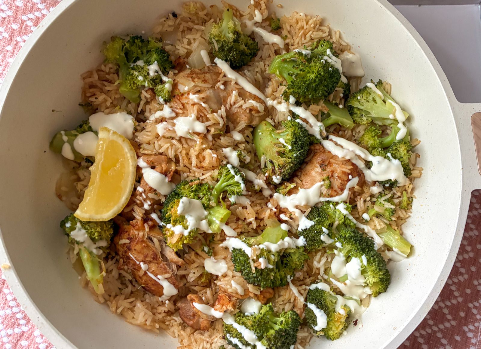 chicken and rice skillet still in the skillet with cream sauce drizzled on top.