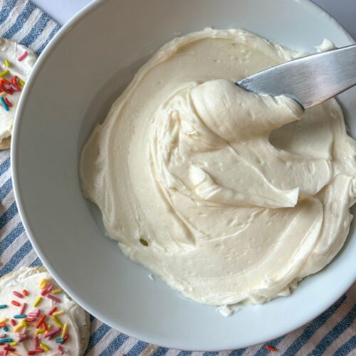 vanilla frosting in a bowl with a knife scooping it out