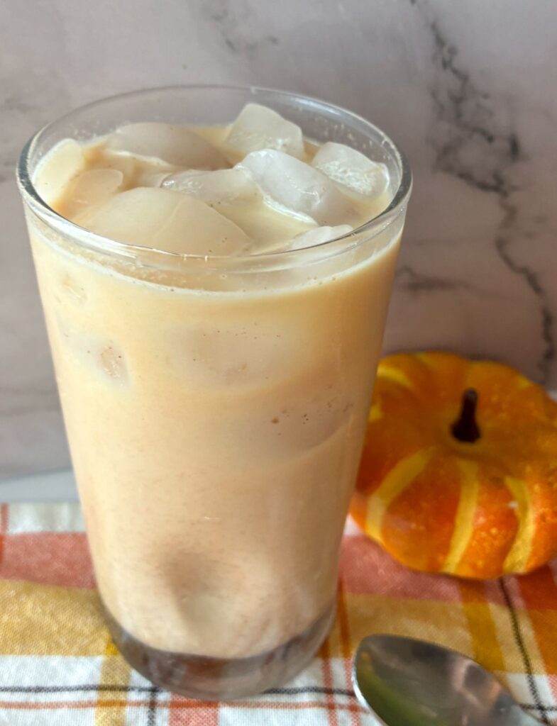 Large glass filled with iced pumpkin chai tea latte