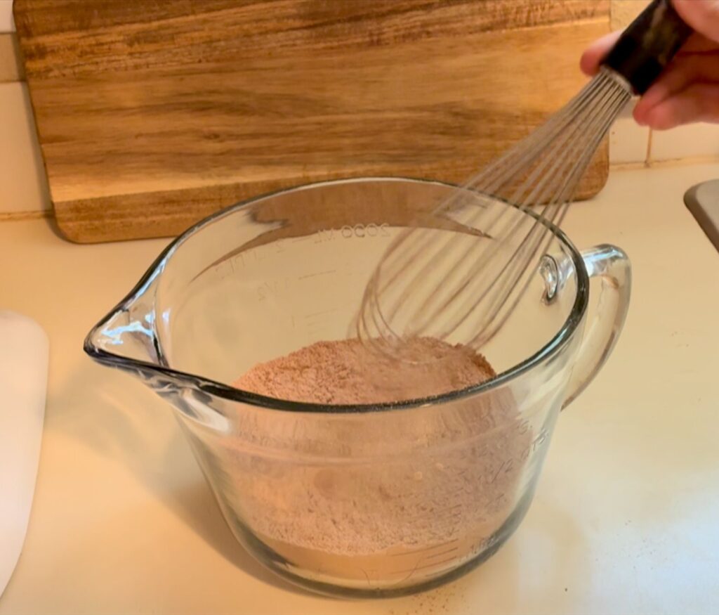 A large bowl with dry ingredients whisked together.
