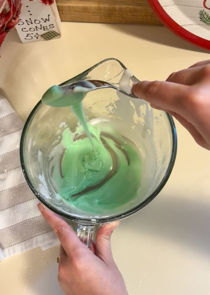 Royal icing in a large bowl after green food gel has been added