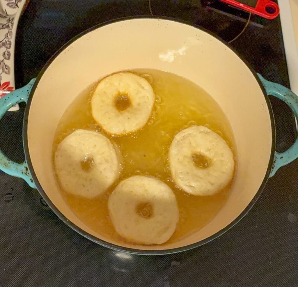 4 biscuits cooking in oil in a large Dutch oven