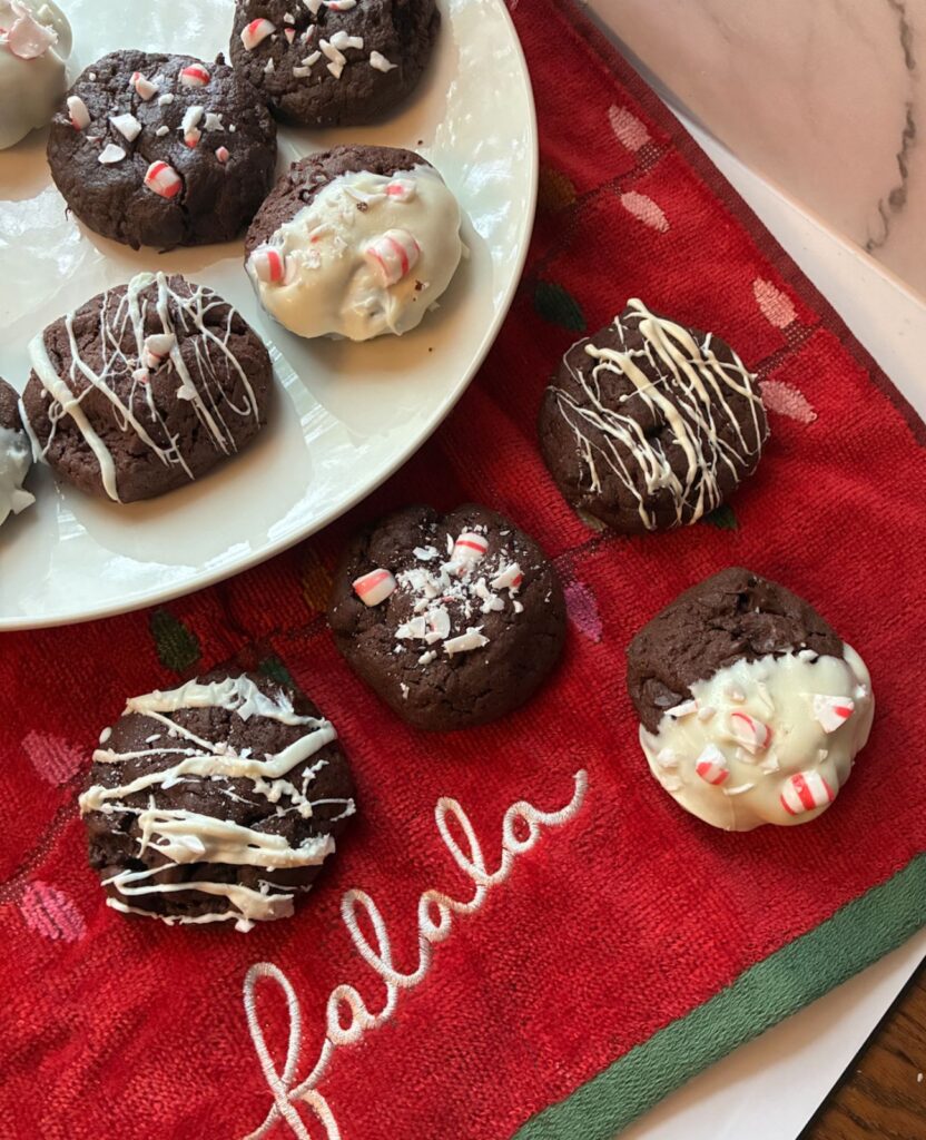 eggless peppermint cookies laid out on a towel that reads "falala" and some cookies are on a white plate