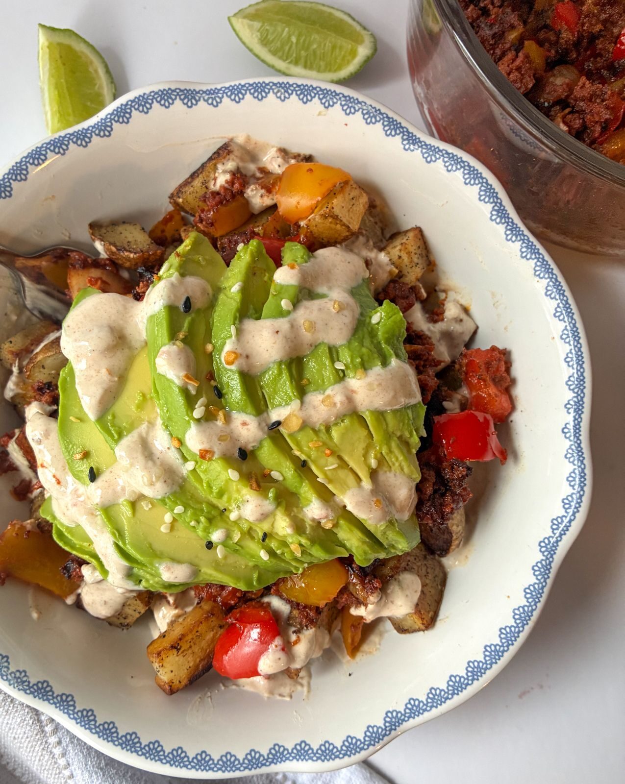 Chorizo breakfast bowl with limes and bowl of chorizo off to the side