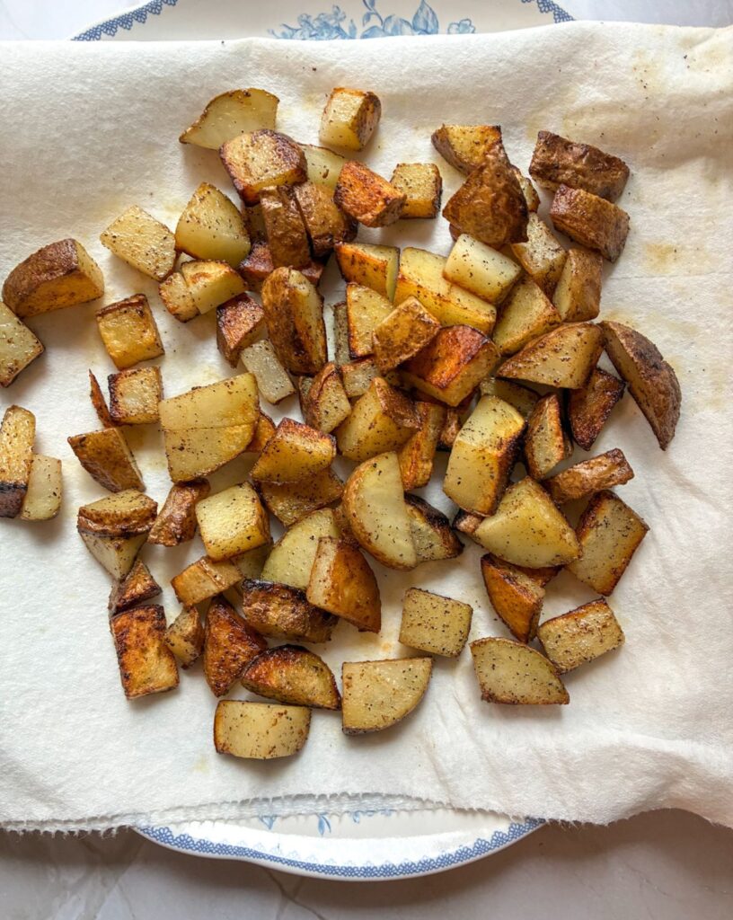 Fried potatoes on a paper towel lined plate