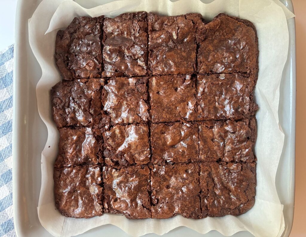 Eggless brownies in a pan sliced into 16 pieces