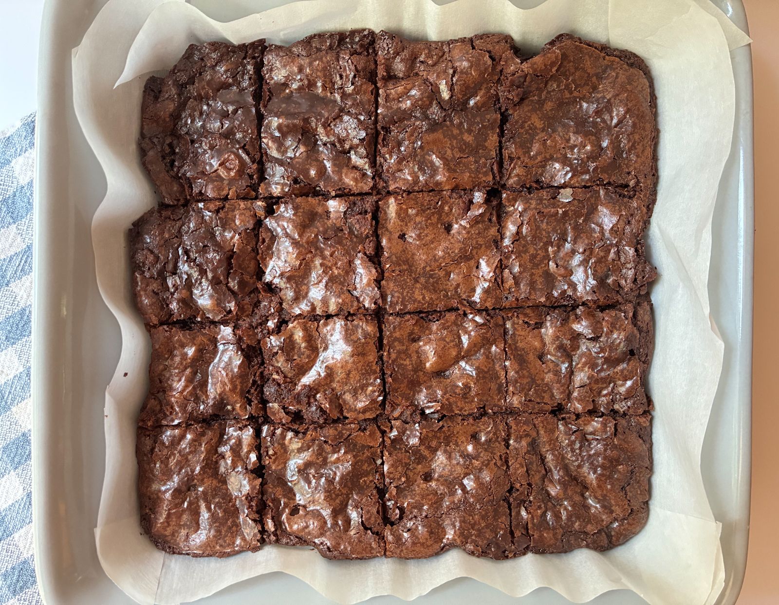 Eggless brownies in a pan sliced into 16 pieces