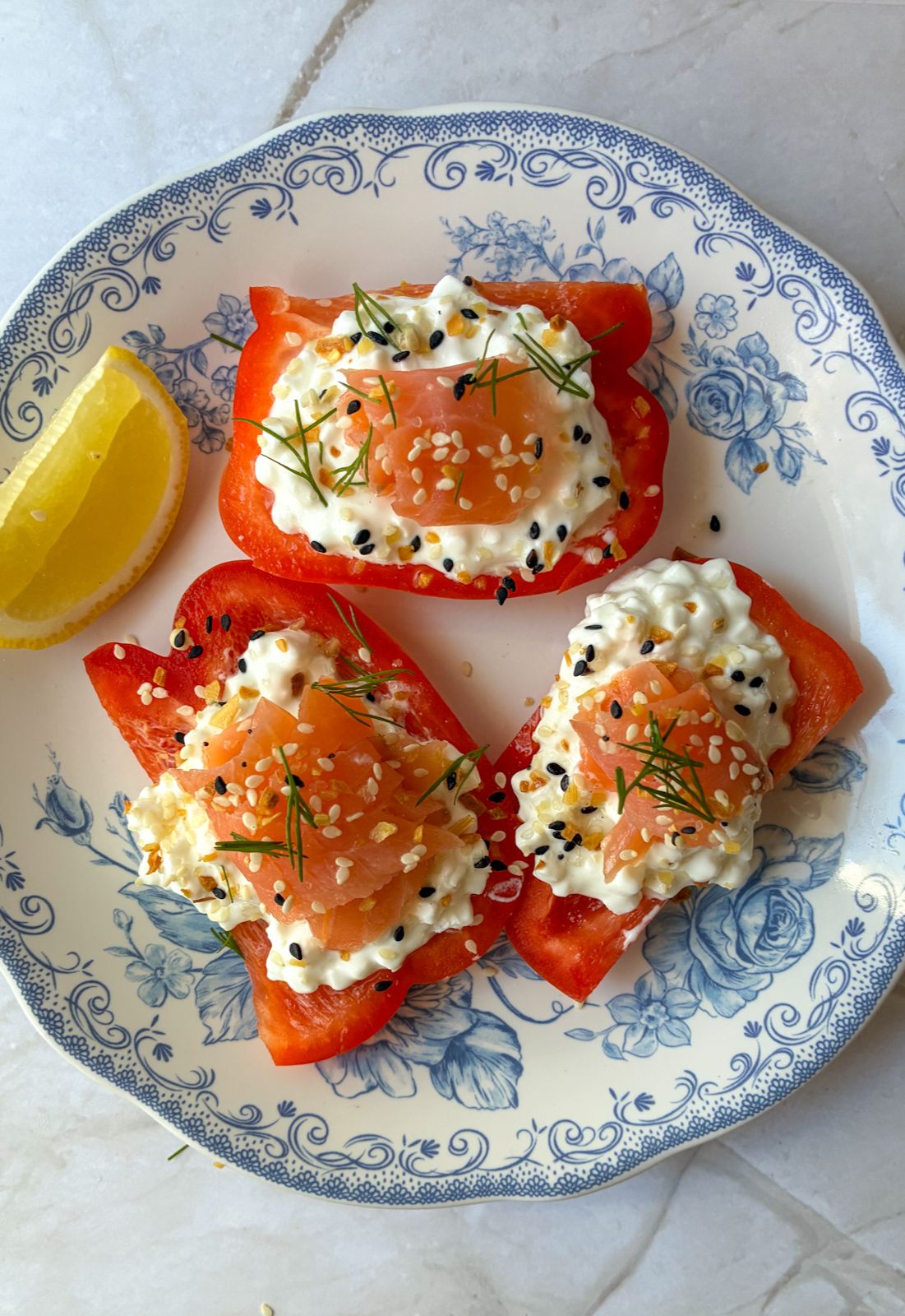 cottage cheese stuffed bell peppers displayed on a plate with a lemon wedge