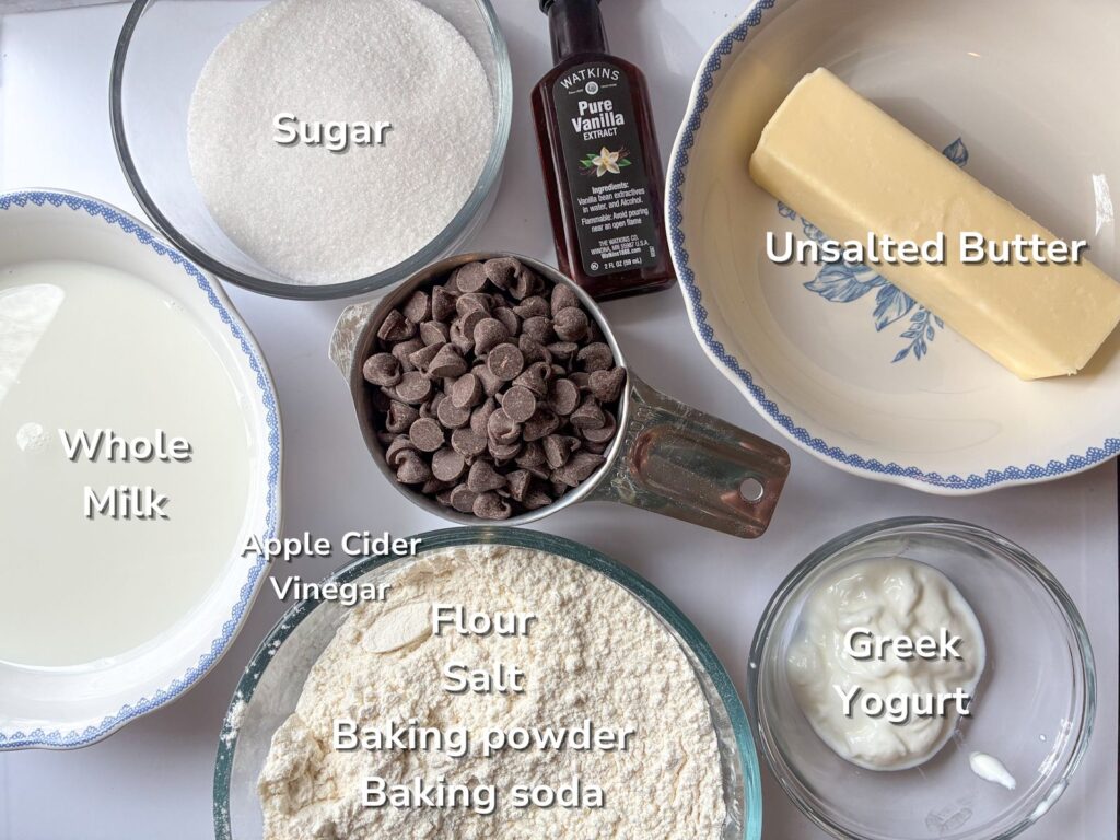 ingredients laid out on a table for eggless chocolate chip muffins with labels on them