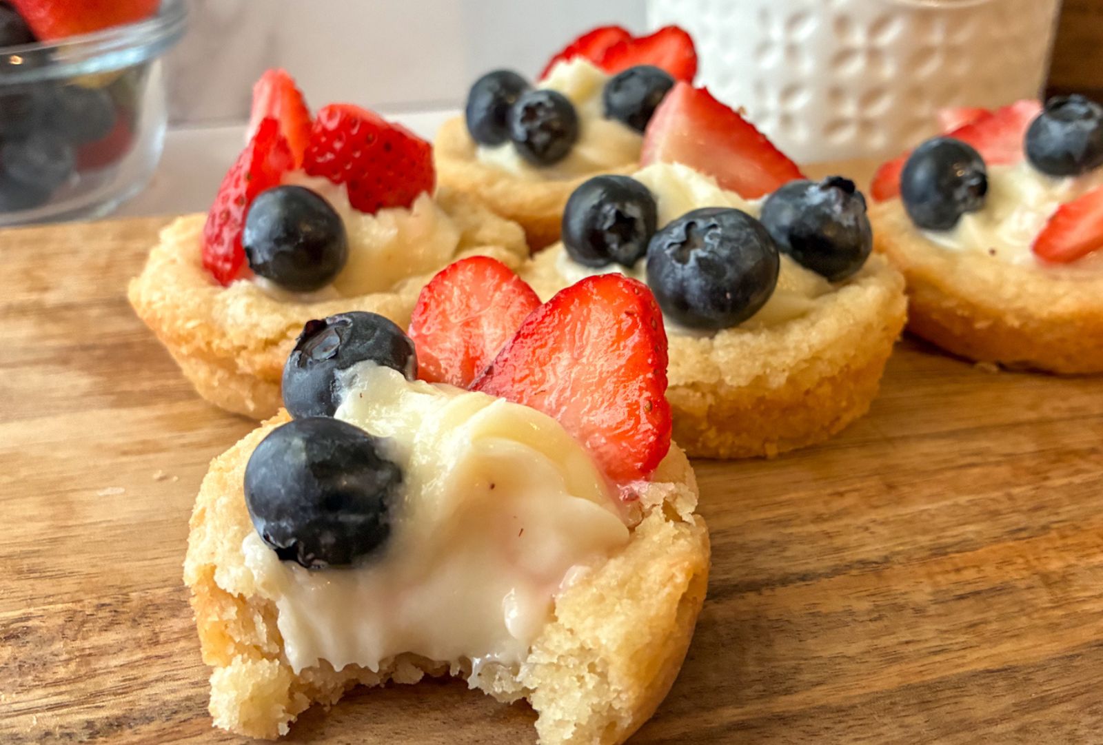 eggless sugar cookie mini tarts one with a bite taken out of them