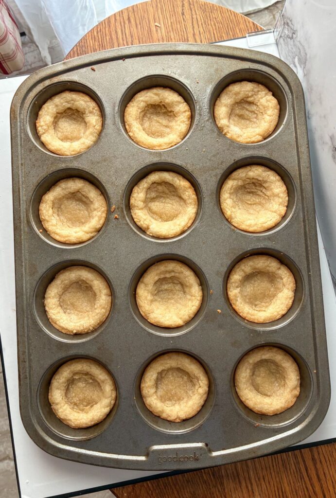 12 cup muffin tin with the center of each mini tart indented down