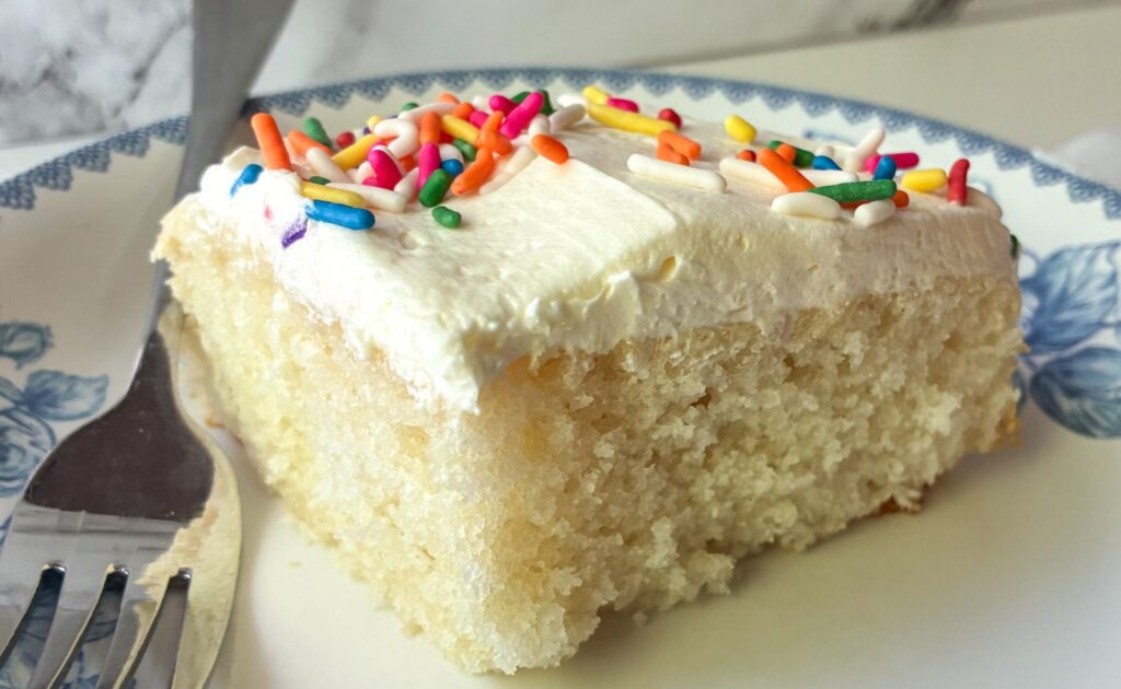 slice of eggless vanilla sheet cake on a plate