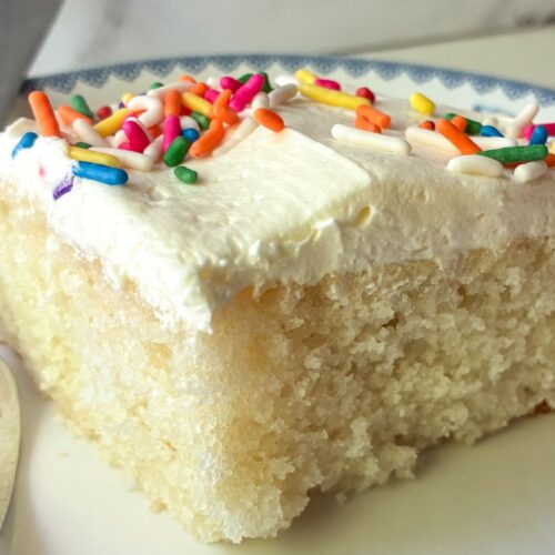 slice of eggless vanilla sheet cake on a plate