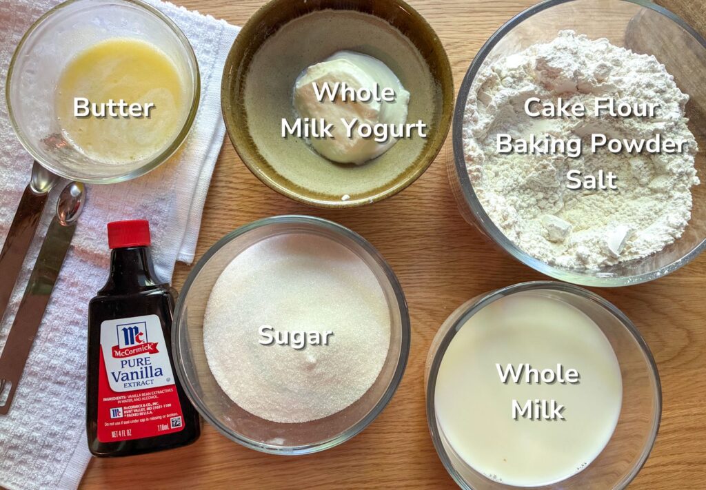 Ingredients in bowls laid out on a table for eggless vanilla cupcakes