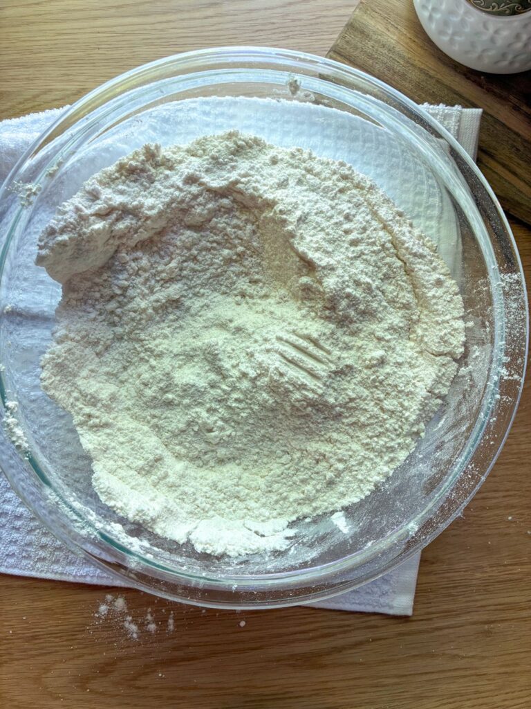 Dry ingredients for eggless vanilla cake in a large bowl