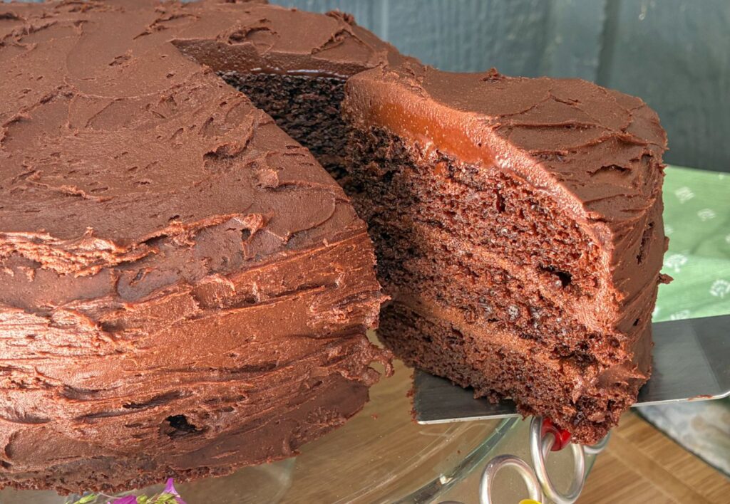 Eggless Chocolate Cake with a slice being pulled out of it