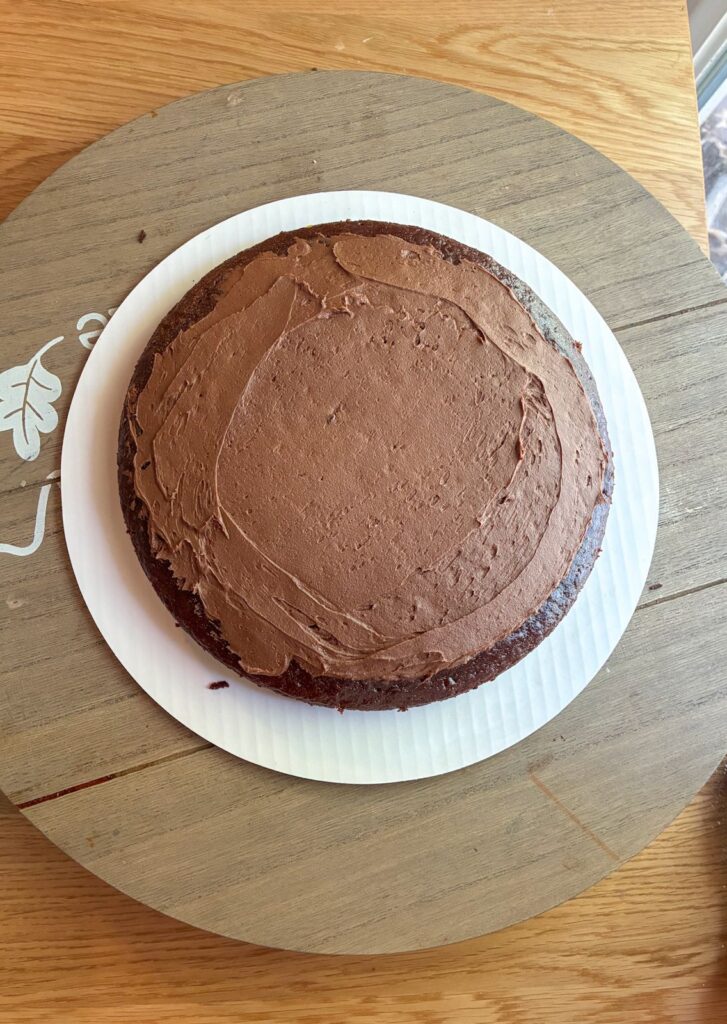 Eggless chocolate cake layer with a thin layer of frosting on top