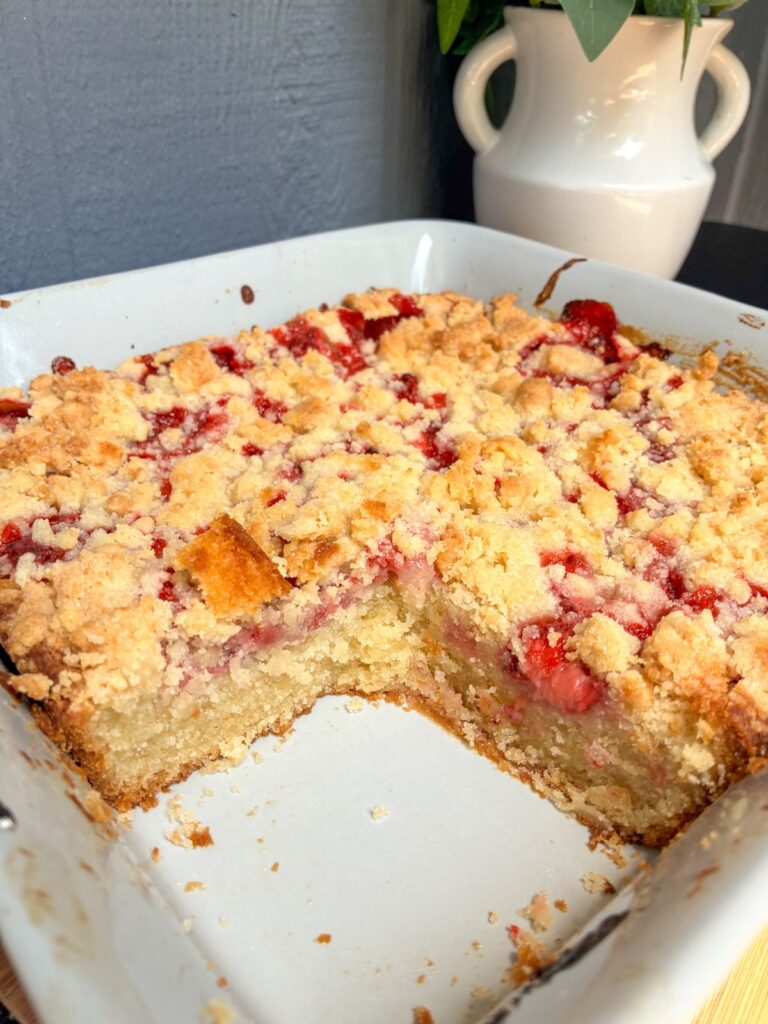 eggless strawberry cake in the pan with a slice taken out