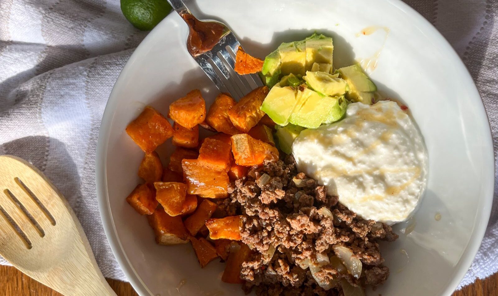 Ground beef hot honey bowl with a wooden spoon next to it