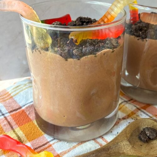 Cottage cheese dirt cup in a clear glass showing the creamy chocolate pudding layer under Oreo dirt and gummy worms