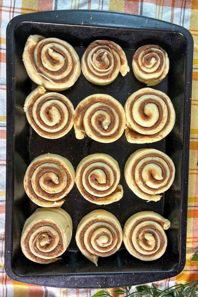 eggless cinnamon rolls after rising in a baking pan
